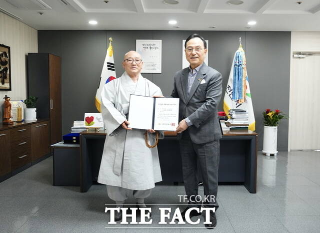4일 박상돈 천안시장이 천안 각원사 주지 대원스님에게 충청남도 문화유산자료 지정서를 전달하고 있다. /천안시