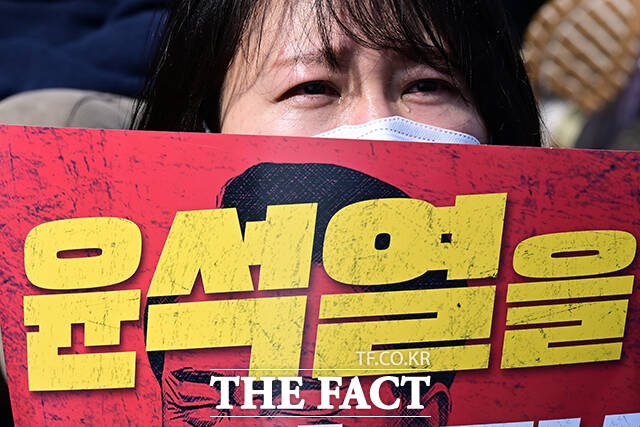 탄핵 찬성 측 집회 참석자가 헌법재판소의 파면 결정문을 들으며 눈물 흘리는 모습.