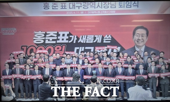 손팻말을 들어 올린 채 홍준표 대구시장과 기념사진을 찍는 간부 공무원들. / 독자 제공