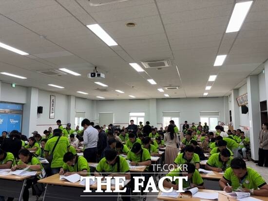 경기 양주시와 하나은행이 함께 마련한 현장 창구를 찾은 외국인 계절근로자들이 15일 현장 통장 개설 서비스를 이용하기 위한 서류를 작성하고 있다. /양주시