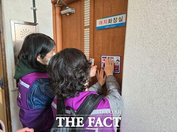 대덕구 여성친화도시 주민참여단이 16일 행정복지센터 화장실에 불법 촬영 탐지카드를 설치한 후 사용 방법 안내문을 부착하고 있다./대덕구