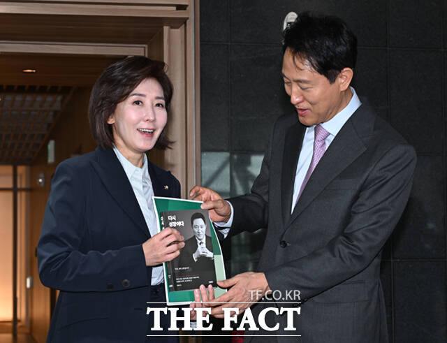 제21대 대통령 선거 출마를 선언한 나경원 국민의힘 의원이 16일 서울특별시청 청사에서 오세훈 서울시장을 예방한 뒤 기념촬영하며 오 시장의 저서를 소개하고 있다. /이새롬 기자