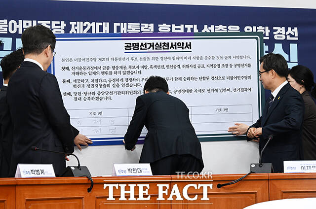 더불어민주당 제21대 대통령 선거 경선 후보자 공명선거 실천 서약서에 서명하는 세 후보자들.