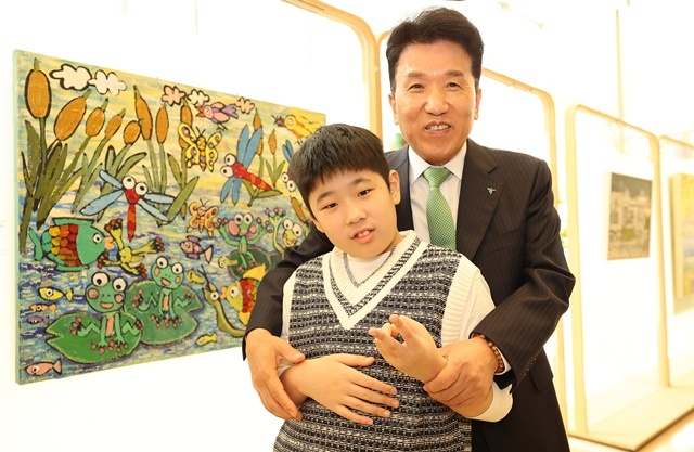 함영주 하나금융그룹 회장(오른쪽)이 17일 아동·청소년부문 우수상 수상작인 이도원 작가의 연못마을 개구리와 친구들 작품 앞에서 이도원 작가와 함께 기념 촬영을 하고 있다. /하나금융그룹