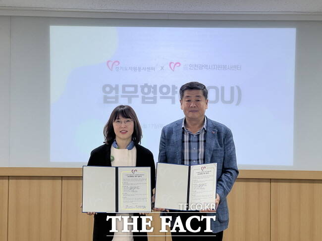 박지영 경기도자원봉사센터장과 박위광 인천시자원봉사센터장이 17일 경기도자원봉사센터 지식나눔실에서 업무협약(MOU)을 체결한 뒤 기념사진을 촬영하고 있다./경기도자원봉사센터