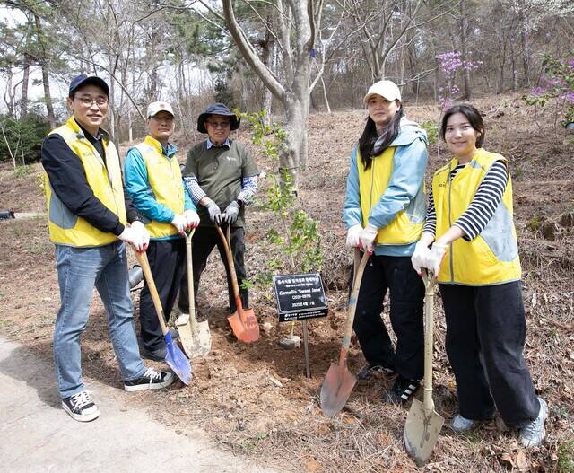 지난 17일 충청남도 태안군 천리포수목원에서 생물다양성 보전을 위한 봉사활동에 참여한 동서식품 임직원들이 나무를 심고 있다. /동서식품