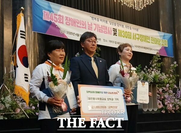 김경휘 대전봉사체험교실 부설 다문화가정연구원장(사진 가운데)이 김예찬 만년중학교 학생의 어머니(사진 왼쪽)와 유태영 성세재활학교 학생의 어머니에게 장학금을 수여한 후 기념 촬영을 하고 있다./대전봉사체험교실