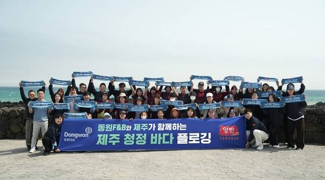 지난 18일 제주 서귀포시 표선면 일대에서 진행된 제주 청정 바다 플로깅 행사에서 동원F&B 직원들이 기념 사진 촬영을 하고 있다. /동원F&B