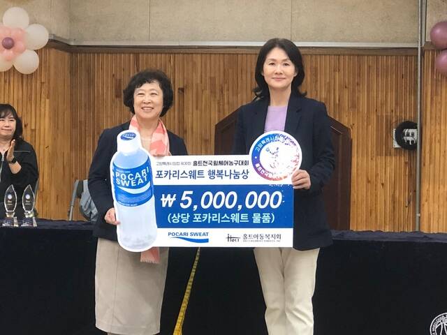 이진숙 동아오츠카 마케팅본부 전무(오른쪽)가 홀트전국휠체어농구대회 관계자에게 포카리스웨트 행복나눔상을 전달하고 있다. /동아오츠카