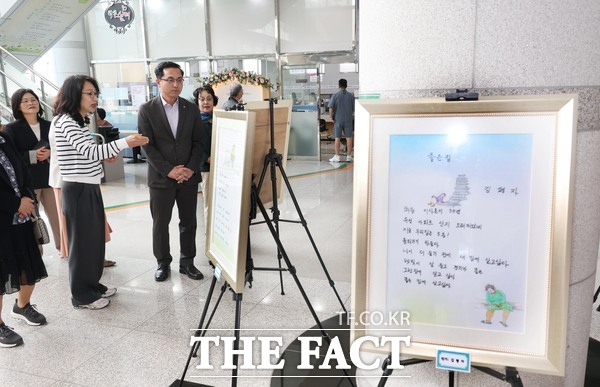 박희조 동구청장이 구청 로비에 전시된 리폼 작품과 시니어 시화전을 감상하고 있다./대전 동구