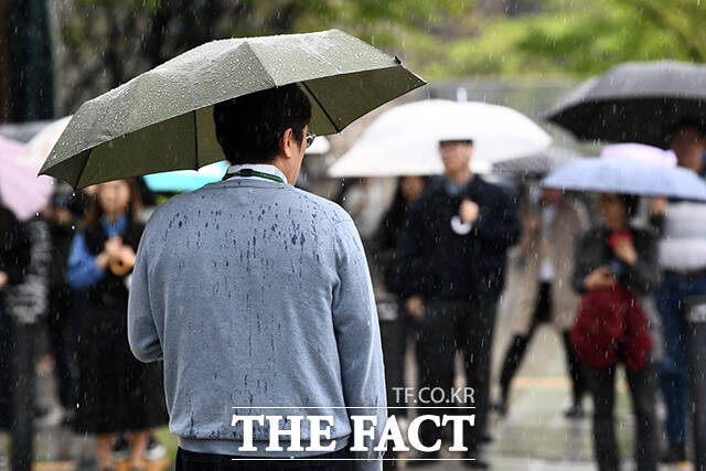 봄비가 내리는 22일 오후 서울 중구 시청역 인근에서 횡단보도 신호를 기다리는 한 시민의 등이 봄비로 젖어 있다. /서예원 기자