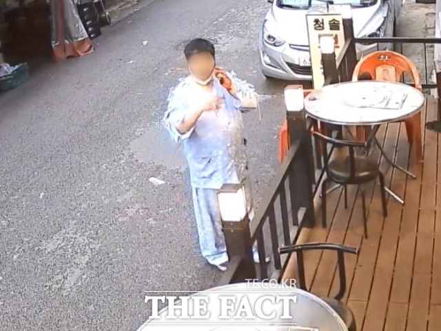 서울 강북구 서울 지하철 4호선 미아역 인근의 한 마트에서 환자복 차림의 30대 남성이 지난 22일 오후 6시20분께 묻지마 칼부림 난동을 벌인 후 식당 앞에서 담배를 피고 있다./독자제공