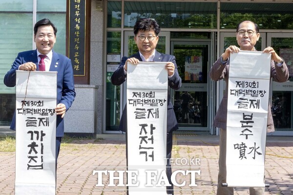 최충규 대덕구청장(사진 가운데)과 전석광 대덕구의회 의장(사진 왼쪽), 임찬수 대덕문화원장(사진 오른쪽)이 26일 동춘당 역사공원 대전무형문화재전수회관 앞 광장에서 열린 ‘제30회 대덕백일장’의 글제를 공개하고 있다./대덕구