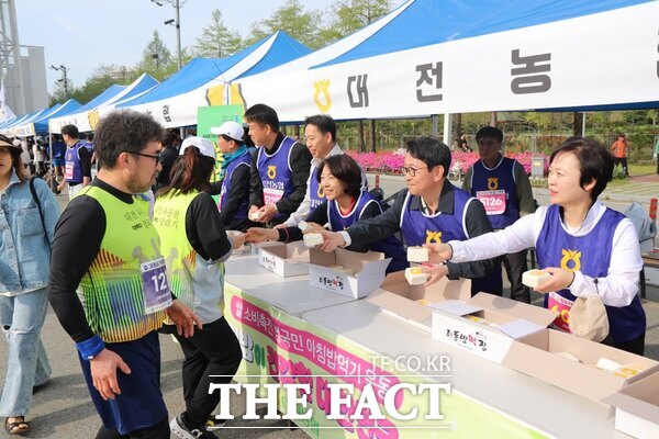 대전농협이 27일 엑스포시민광장에서 제21회 3대하천 마라톤행사에 참석한 대전시민 4000여 명을 대상으로 백설기를 나눠주며 쌀 소비촉진 캠페인을 펼쳤다. /대전농협