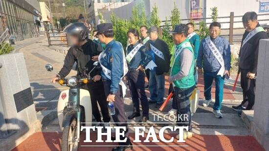 경기 구리시 및 구리경찰서와 갈매동 주민들이 최근 갈매천 산책로에서 한 오토바이 운전자를 상대로 통행 근절 민관 합동 캠페인을 벌이고 있다./구리시