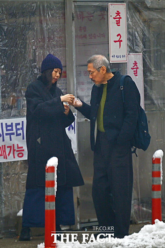 홍상수 감독(오른쪽)은 최근 김민희와 함께 아들을 품에 안았다. 사진은 지난해 11월 경기 남양주시 인근에서 설경을 즐기고 도너츠를 사 먹으며 데이트를 하고 있는 모습. /남윤호 기자