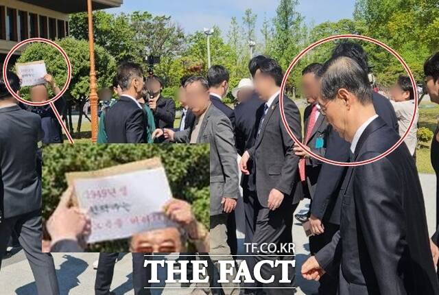 한덕수 전 국무총리(오른쪽 원 안)가 2일 대선 출마 선언을 위해 서울 여의도 국회 소통관을 찾은 모습. 한 남성이 1949년생 한덕수는 노욕을 버려라라는 문구가 적힌 종이 피켓을 들고 있다. /서다빈 기자