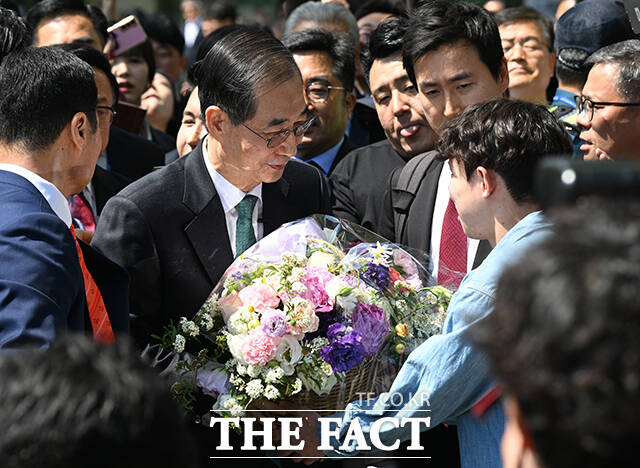 한덕수 전 총리가 대선 출마 선언 후 5·18 민주묘지를 찾은 것과 관련해 더불어민주당이 5월 영령을 능멸했다고 비판했다. 사진은 2일 대통령 선거 출마 선언을 마치고 지지자로부터 꽃바구니를 건네받는 모습. /국회=박헌우 기자