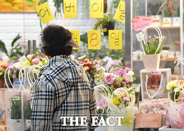 어버이날이자 목요일인 8일은 전국이 대체로 맑다가 밤부터 차차 흐려지겠다. 내륙을 중심으로 낮과 밤의 기온차가 15도 내외로 크겠으니 건강관리에 유의할 필요가 있겠다. 사진은 서울 서초구 지하상가에서 한 시민이 꽃 구경하고 있는 모습./박헌우 기자