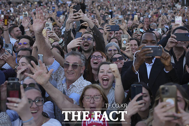 광장에 있던 사람들이 환호하고 있다.