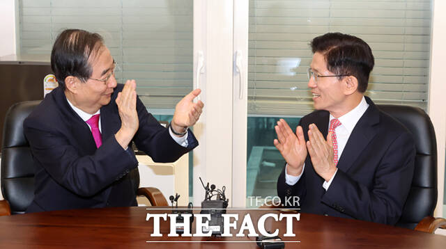 김문수 국민의힘 대선후보(오른쪽)와 한덕수 전 국무총리가 11일 서울 여의도 국민의힘 대선후보 사무실에서 만나 서로를 향해 박수치고 있다.