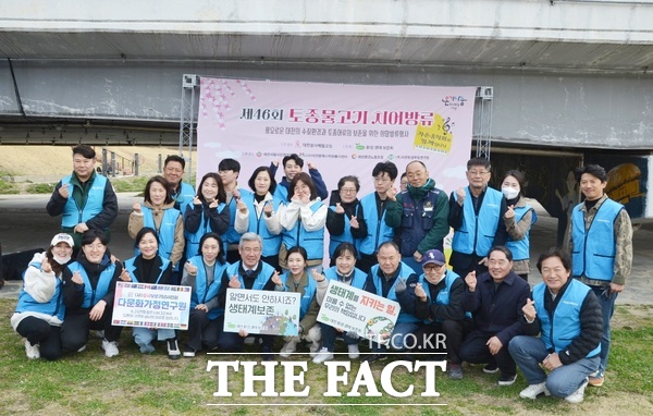 어머니 조선희(앞줄 왼쪽 첫 번째) 씨와 오병택(앞줄 왼쪽 두 번째) 군이 환경보호를 위한 토종물고기 방류 봉사에 함께하고 있다. /선치영 기자