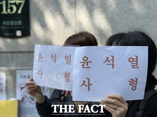 내란 우두머리 혐의로 기소된 윤석열 전 대통령의 세 번째 재판이 열린 12일 서울중앙지법 동문 앞에서 여성 2명이 윤석열 사형 손팻말을 들고 있다. /정인지 기자