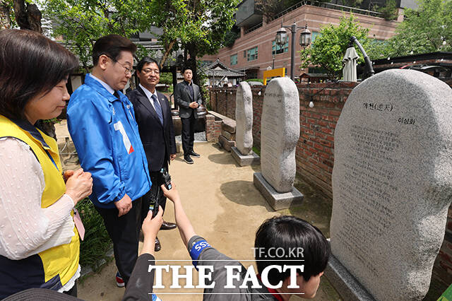 이 후보가 해설사의 설명을 들으며 역천을 읽고 있다.