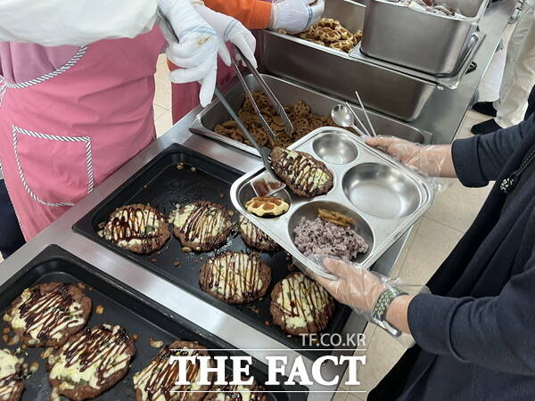 동명중학교 조리원들이 학부모들에게 급식을 배식하고 있는 모습 /정예준 기자