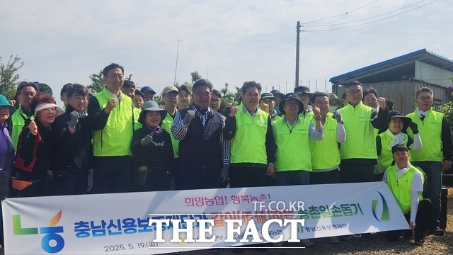 19일 충남신용보증재단과 농협 임직원들이 예산군 사과 농가를 찾아 농촌 일손돕기에 들어가기 전에 기념 촬영을 하고 있다. /충남신용보증재단