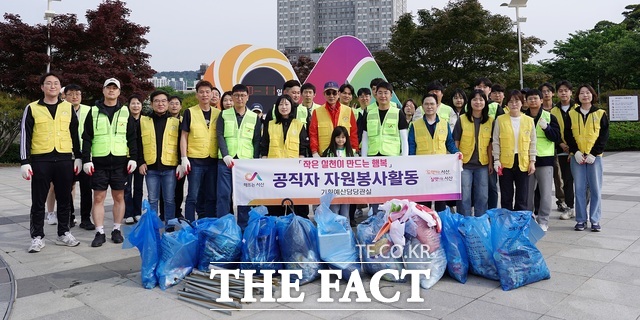 서산시 중앙호수공원 일원에서 18일 진행된 환경정화 활동 후 시 2기 청년네트워크 회원과 시청 기획예산담당관실 직원들이 이완섭 시장과 함께 기념촬영을 하고 있다./ 서산시