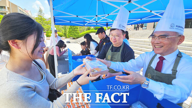20일 정오 목원대 중앙도서관 앞에서 열린 ‘총장이 쏜다’ 행사에서 이희학 총장(오른쪽)이 한 학생에게 런치박스를 전달하고 있다. /목원대