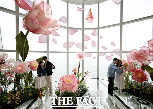 서울 잠실 롯데월드타워 전망대 서울스카이에 플라워 체험형 공간 블루밍 유니버스 : 빅플라워(Blooming Universe : Big Flower)가 오픈한 가운데, 20일 서울스카이를 찾은 시민들이 대형 꽃을 배경으로 기념촬영하고 있다. /이새롬 기자