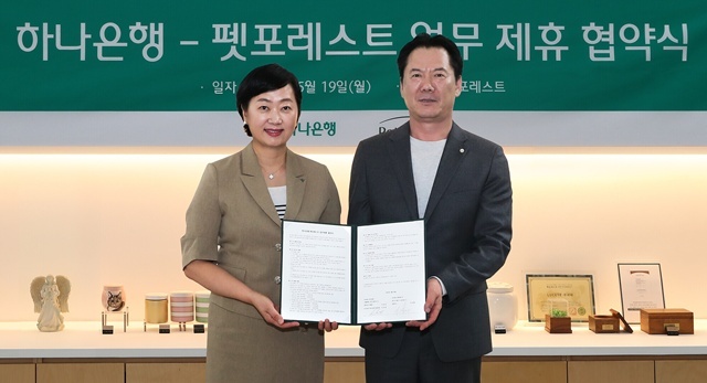 하나은행은 지난 19일 반려동물 장례서비스 제공 업체인 펫포레스트와 수신 VIP 손님 지원을 위한 업무협약을 체결했다. 이날 협약식에 참석한 이은정 하나은행 하나더넥스트본부장(왼쪽)이 이상흥 펫포레스트 대표와 함께 협약서를 들고 기념 촬영을 하고 있다. /하나은행
