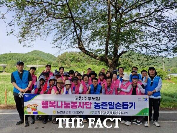 고향주부모임대전시지회 행복나눔봉사단 등 30여 명이 21일 대전 동구 삼괴동 포도농가를 찾아 농촌일손 돕기에 나선 뒤 기념촬영하고 있다. /대전농협