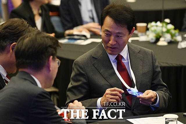 불이 들어오는 명찰 살펴보는 오세훈 시장.