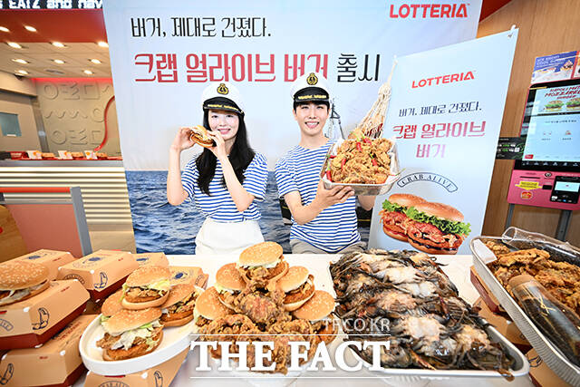 롯데GRS의 버거 프랜차이즈 롯데리아가 21일 오전 서울 중구 롯데리아 동대문역사문화공원역점에서 신메뉴 크랩 얼라이브 버거 출시 기념 행사를 진행한 가운데 모델들이 포즈를 취하고 있다. /서예원 기자