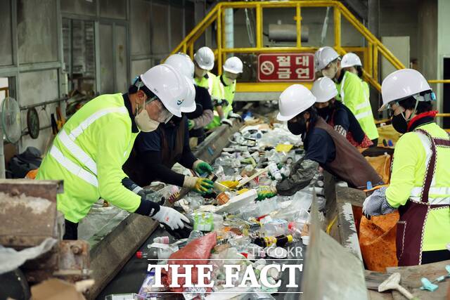 김성 장흥군수와 환경관리과장 등 8명의 공직자들이 재활용 선별장을 찾아 쓰레기 선별작업을 하고 있다. /장흥군