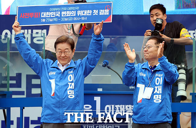 이재명 더불어민주당 대선 후보(왼쪽)가 22일 오후 경남 양산시 양산워터파크공원에서 열린 집중유세에 참석해 사전투표 독려 현수막을 펼쳐보이고 있다. /양산=배정한 기자