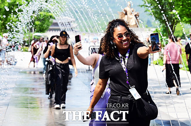 낮 최고 기온이 27도까지 오르며 더위가 시작된 22일 오후 서울 광화문 광장을 찾은 외국 관광객들이 분수 터널을 지나며 즐거운 시간을 보내고 있다. /임영무 기자