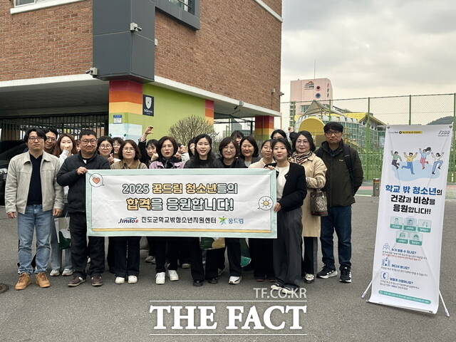 진도군학교밖청소년지원센터 관계자들이 검정고시 시험장 앞에서 학교 밖 청소년들의 합격을 기원하고 있다. /진도군