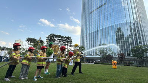 소방안전교육에 참여한 어린이들이 화재 진압 훈련을 하고 있다. /롯데물산