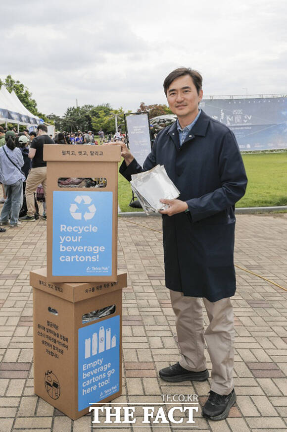 쓰저씨(쓰레기 줍는 아저씨) 배우 김석훈이 직접 모은 멸균팩을 들고 재활용 캠페인을 독려하고 있다.