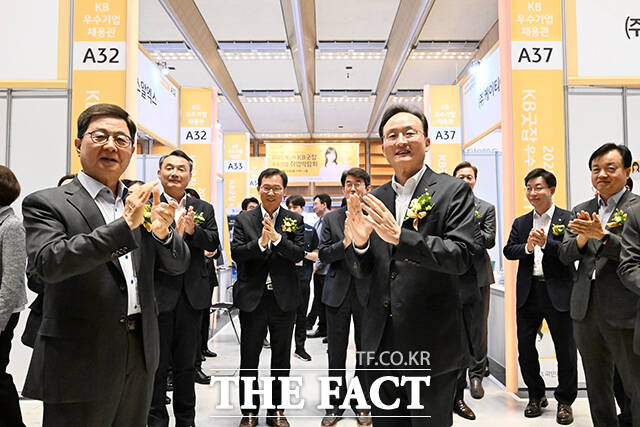 이달곤 동반성장위원회 위원장(왼쪽)과 이환주 KB국민은행장이 26일 오전 서울 강남구 코엑스 D홀에서 열린 2025 제1차 KB굿잡 우수기업 취업박람회에 참석해 참여 업체 부스를 살펴본 뒤 박수를 치고 있다. /서예원 기자