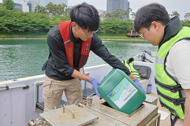 롯데물산 관계자가 서울시 송파구 석촌호수에서 수질 정화 작업을 진행하고 있다. /롯데물산