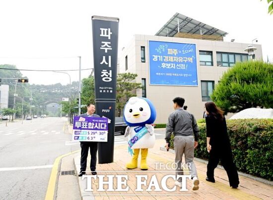 김경길 경기 파주시장(왼쪽)이 파주시 대표 캐릭터인 ‘파랑’과 함께 파주시청사 앞을 지나는 시민들을 향해 투표 참여 독려 캠페인을 진행하고 있다./파주시