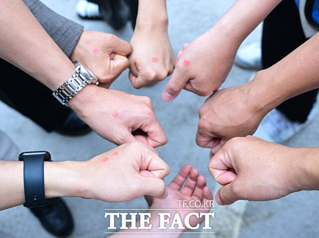 사전투표를 마친 시민들이 손등에 투표도장을 찍은 뒤 손을 모아 기념촬영하고 있다. 손등이나 손가락에 도장을 찍는 것은 이미 잘 알려진 투표인증 방식이다.