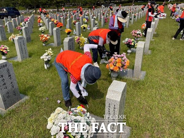 농협대전본부는 대전농협 여성단체 봉사단과 임직원 등 총 100여 명이 참여한 가운데 30일 국립대전현충원을 찾아 3000여 개 묘소에서 테극기를 꽂고 묘비닦기, 잡초 제거 등 봉사활동을 하고 있다./농협대전본부