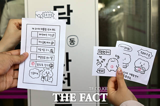 사전투표를 마친 시민들이 캐릭터 그림과 최애 음식표에 투표 도장을 찍어 인증하고 있다.