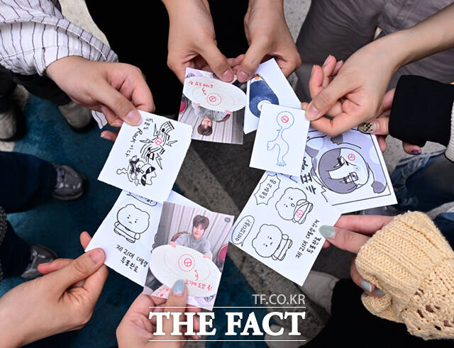 제21대 대통령선거 사전투표 둘째날인 30일 서울 강남구 청담동 주민센터에 마련된 사전투표소에서 투표를 마친 시민들이 도장을 찍은 캐릭터 그림이나 아이돌 사진을 들고 기념촬영하고 있다. /이새롬 기자